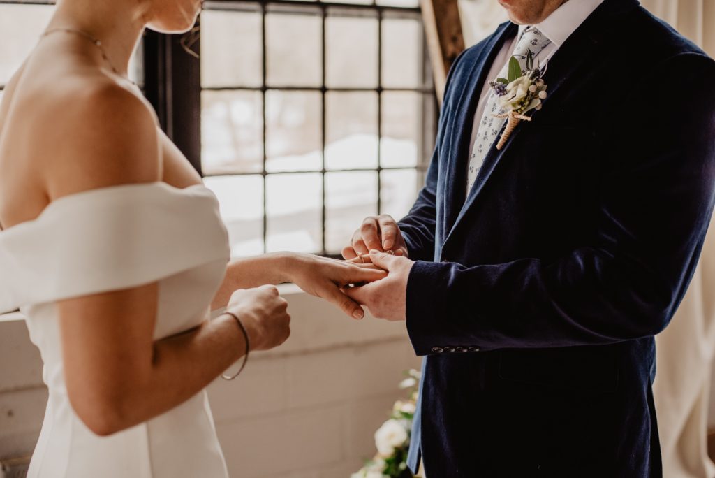 Groom puts ring on brides finger